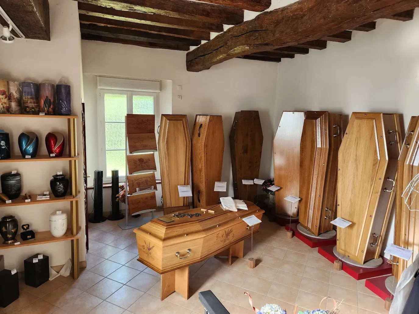 Exposition de cercueils en bois et d'urnes cinéraires en boutique.